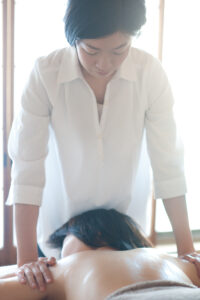 アロマトリートメントの施術風景。背中に優しくアプローチし、リラックス効果を高めるトリートメント。