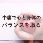 手のひらの中に赤いハートがあり、『中庸で身体と心のバランスを取る』というメッセージが込められた画像。